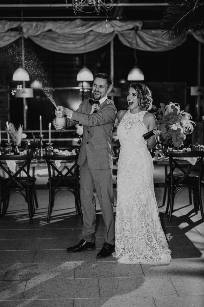 Brautpaar beim Feiern am Tag ihrer Hochzeit mit Schaumwein