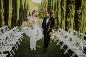 Brautpaar beim Auszug nach der freien Trauung bei eleganter moderner Hochzeit mit Brautstrauß